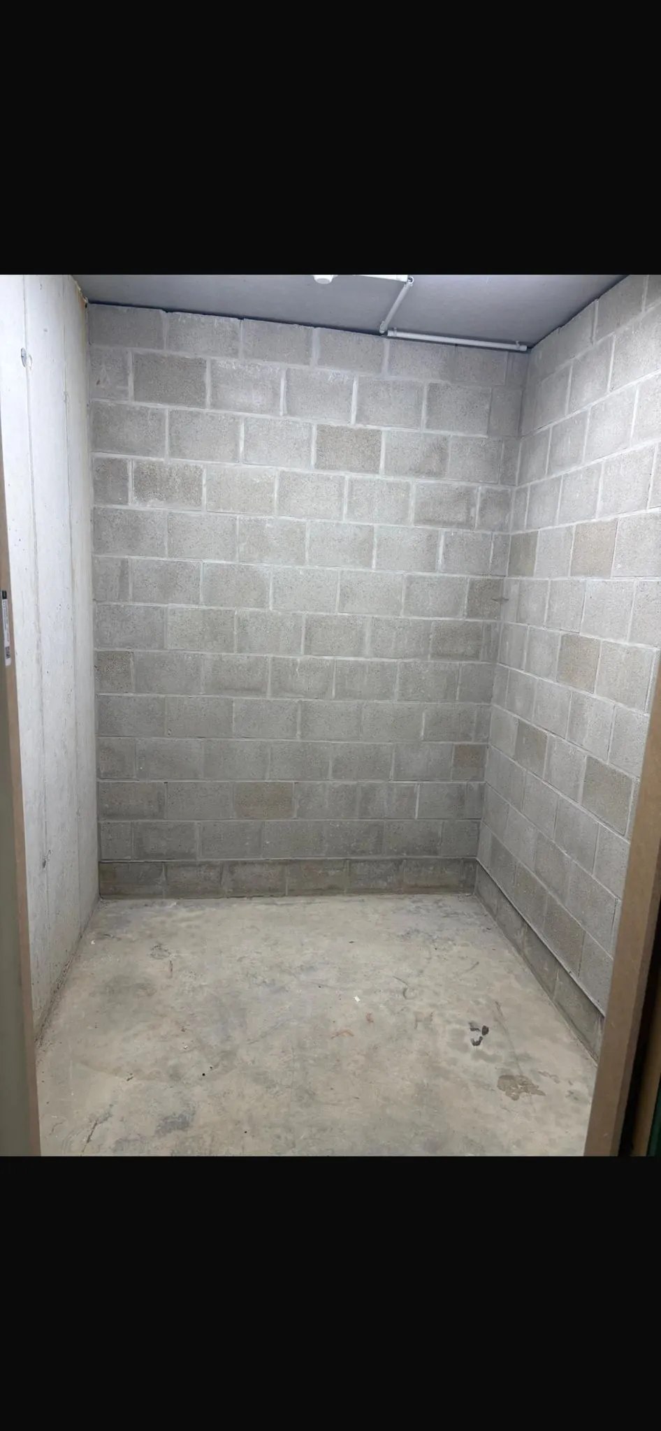 Storage unit 1×1 m interior — concrete block walls, LED lighting