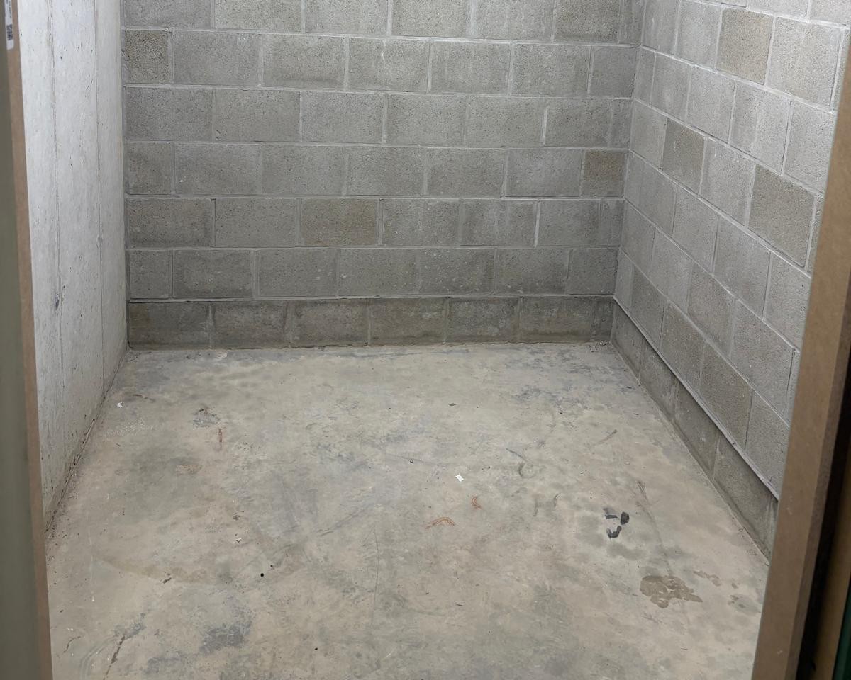 Storage unit 1×2 m with white door — concrete walls, pallet floor